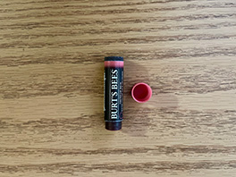 An empty container of a Rose Tinted Burt's Bees Lip Balm