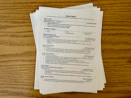 A pile of black and white resumes